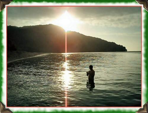 Postcard Moment - One of the best personal photos I took in one of the best trips I've taken. My friend taking a cold dip in the shores of South China Sea, from the Philippines' last landmass in the northern region, under the beautiful sunset.