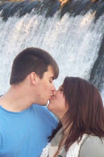 is it really love - son and girl friend in front of waterfall. in love