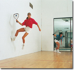 racquetball - lady jumping off wall to return ball