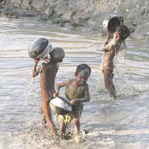 kids - Kids enjoying themselves in a dirty rivulet.