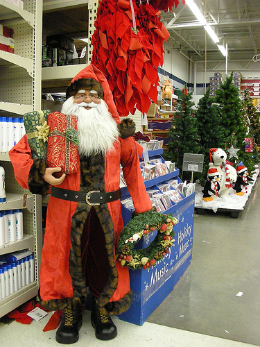 Christmas Shopping with Santa Claus - A photo of Santa Claus standing beside a shop for the Christmas shopping craze.