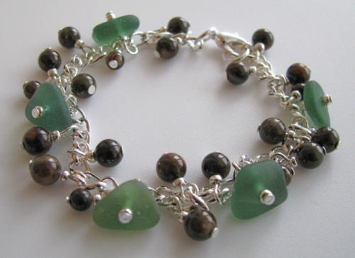 Deep Green Sea Bracelet - A 7 1/2' silver plated bracelet adorned with five pieces of teal and forest green sea glass, accented with dark brown polished shell beads and finished with a lobster clasp.  Teal sea glass is considered to be one of the rarer colors and a couple of the teal pieces look awesome in the sunlight. A pretty bracelet, very dainty and feminine accessory.