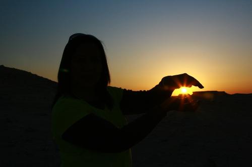 holding half of it - We've waited for the sunset during our trip out of the city. It was taken in Zikreet, wherein you can find the rocks formation in Qatar.