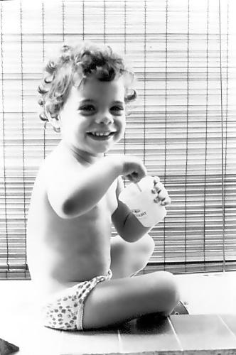 carol & yogurt - This photo was taken in 1980 - using a Kodak Retinette IIb, B&W 135mm Kodak film. My daughter Carol (then 2 years old) was finishing her morning yogurt.  I tried to capture the bright sunlight against the indoor shadows.  This photo won me a local amateur photographic award, for composition, texture and subject.  Frank