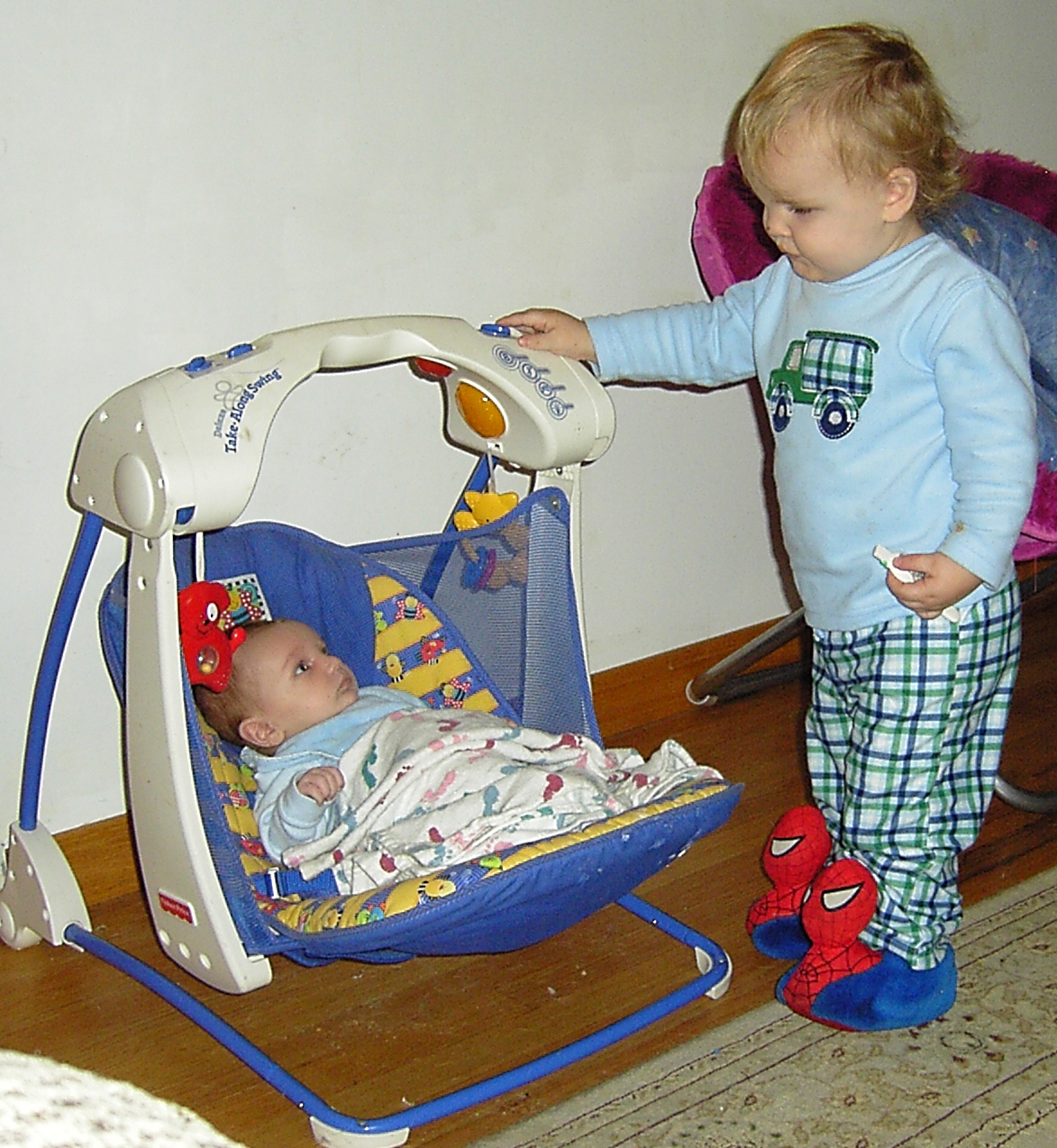 takin care of his brother - Kameron comforting his brother in the baby swing....how cute!