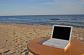 Laptop on table by beach - photo of Laptop on table by beach