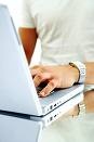 Person using a laptop - Its an image of a person operating on a laptop, with only the operator's hand and the laptop's back visible