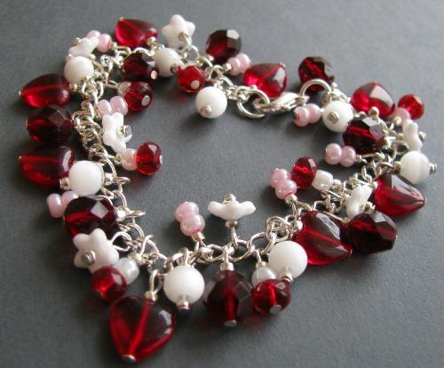 Be Mine Bracelet - This 7 1/2' silver plated bracelet is adorned with Czech glass Ruby Red Hearts, and deep red faceted beads, accented by tiny white glass flowers, white cats-eye beads, pearly white with red glass beads & pearly pink E beads. Finished with a lobster clasp.