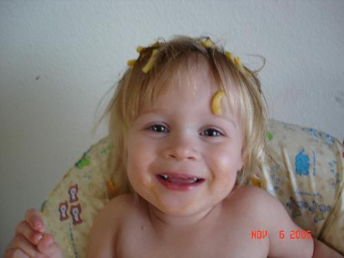 playing with food. - My two yr old decided to wear her macaroni for a hat.