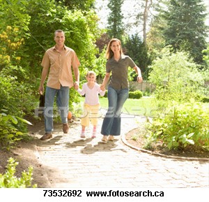 Parents walking through the park with child - parents enjoying a day at the park with child