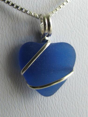 Cobalt Blue Sea Glass Heart Necklace - This petite piece of cobalt blue sea glass has been tumbled by the sea, into a delicate heart shape... and just in time for Valentine's Day! Measuring just shy of 1/2' in length, this pretty cobalt blue ocean treasure is wrapped in sterling silver wire, and hangs on an 18' sterling silver Venetian box-style chain.  Images are provided to gauge the size of this piece of authentic sea glass. The coin was used as a comparison and is not included with the necklace.