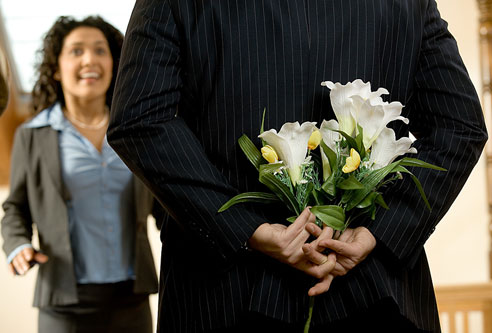 romance - dating couple man holding flowers in his hand