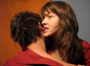 Ear nibble - Woman nibbling playfully on a man's ear.