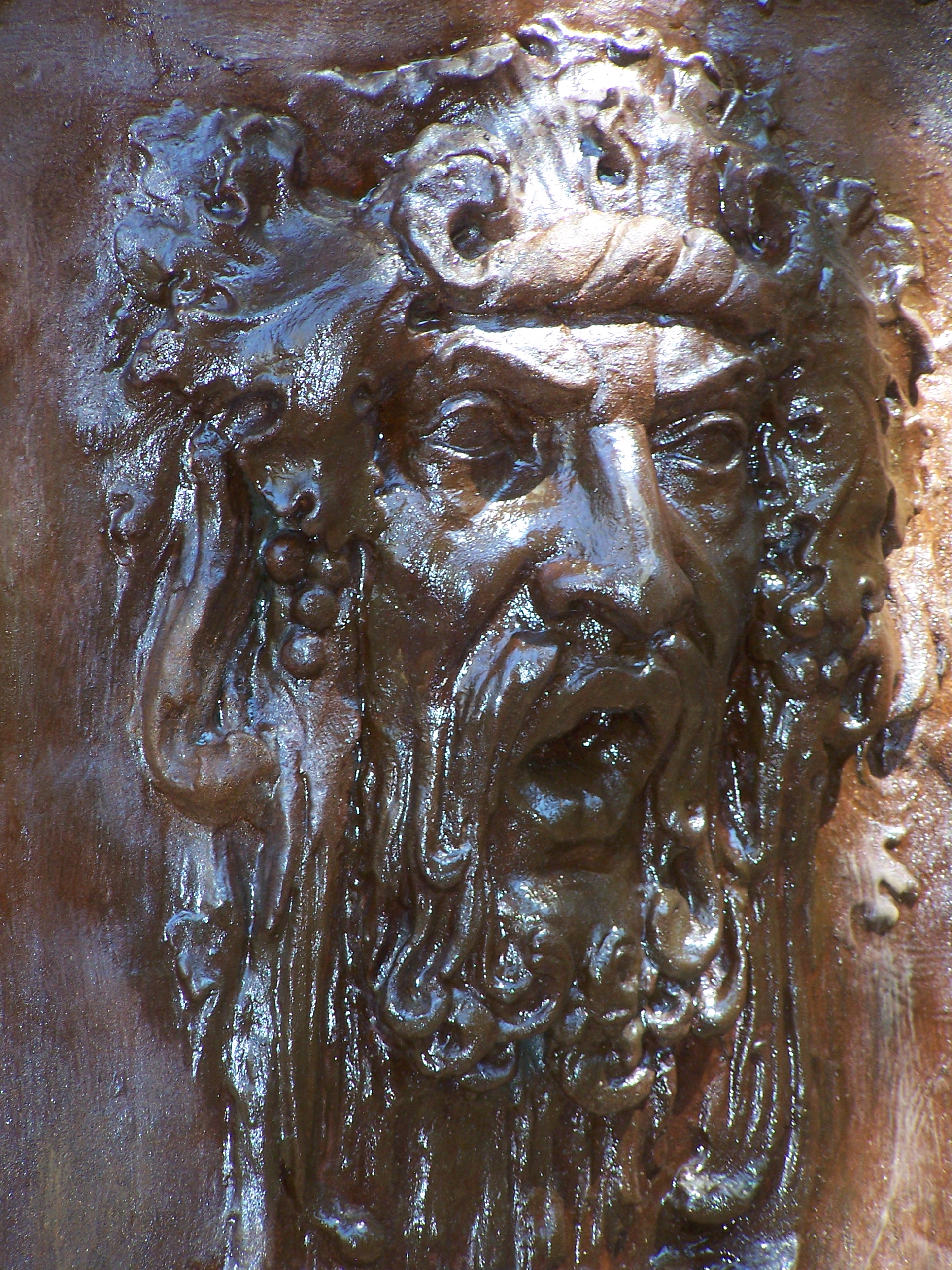 This is the roman god Bacchus. - Bacchus, shown here in a bas relief made in plaster and faux finished to look like weathered bronze, was the god of the vineyards and the original 'Party Guy'.