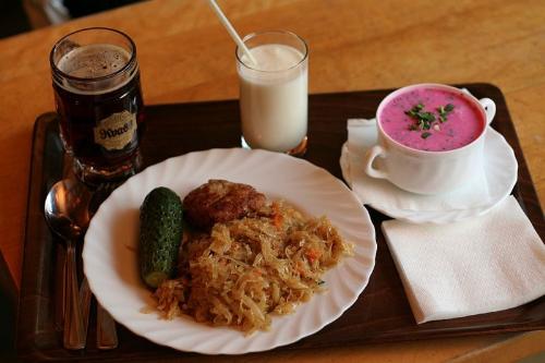 Latvian traditional food - A cold soup, pot cooked cabbage, a cotlette, a gjerkin, sour milk (kefir) and some Russian kvas.