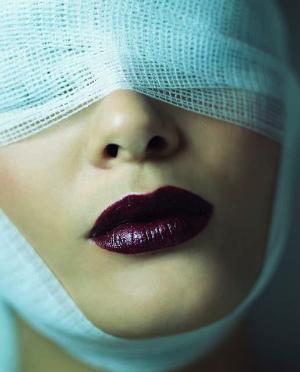 Plastic surgery - a woman after plastic surgery, her face is bandaged. 