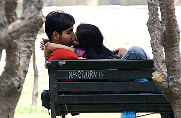 Kissing in the public - A couple kiss in a public park.
