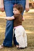 Parents - Child clinging to parents leg