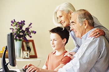 Old people and computers - A family with a little boy, his grandmother and grandfather are using computer.