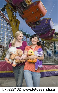 Two teenage girls carrying stuffed animals and lau - Laughing teenage girls carrying stuffed animals