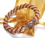 Bead Crochet Bracelet - This is just one of my bead crochet creations that I have for sale in my Etsy shop: http://pinkap.etsy.com. This is made with two colors, light pink/peach and amber, that surround a Jasper stone. The bead caps are Bali silver, and the whole thing was crocheted using a celery color c-lon nylon cord.