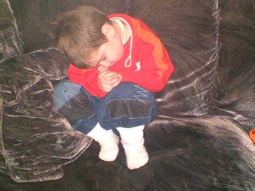 My son after he fell asleep on the couch - This is my son he fell asleep on the couch after I sat him there, so i could get his snowsuit on to go out.