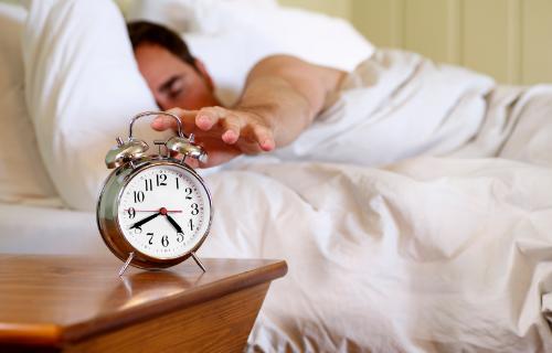 Waking Up - Sleeping man is waking up by his alarm call.