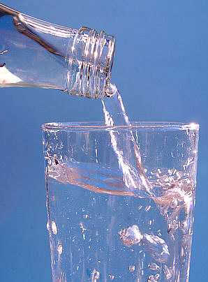 pouring a glass of water from a bottle - Here is someone pouring a glass of mineral water into a glass.