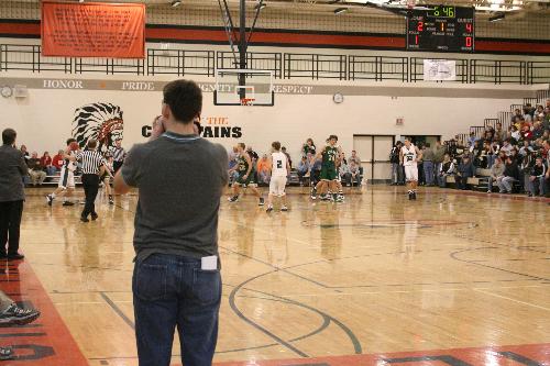 TV reporter in front of others at a game. - This was taken with a Canon Digital Rebel Xt