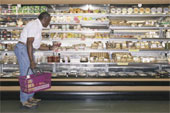 Grocery shopping - Elderly man shopping at a supermarket holding a shopping basket