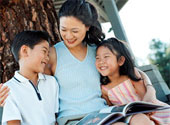 Reading - Mother and children reading outdoors.