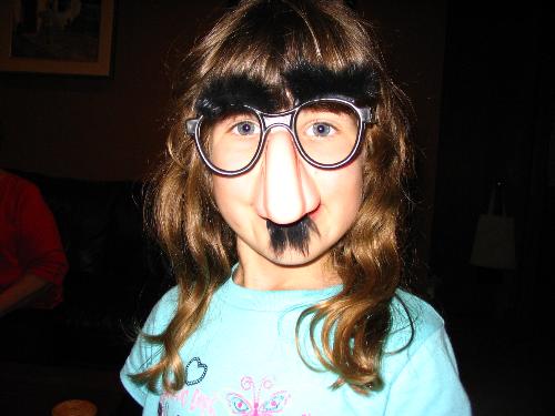 Mia being silly - This is my middle child Mia. She likes to be silly and get people laughing even if it means she has to wear a Groucho Marx nose and mustache. Too bad the dog tore it apart because apparently the mustache looked a lot like a small rodent.