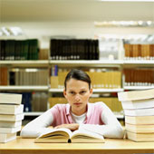 Studying - Front view portrait of young woman studying in library