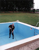 pool - A man cleaning an emptied swimming pool