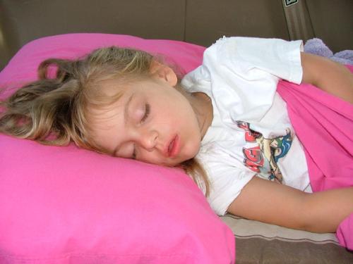 kid sleeping - a cute girl sleeping in a pink pillow