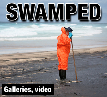 Man cleaning oil up - This is a photo of a man clenaing up a oil spill that happened on Australia.