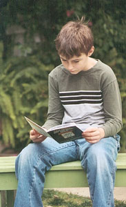 reading - a kid reading outdoor.