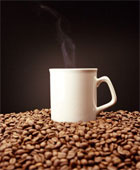 Coffee - Steaming mug of coffee on mound of coffee beans