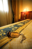 Hotel - Close-up of a hotel room key lying on the bed in a hotel room.
