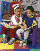 reading - Girl Helping Boy Read In Classroom