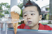 Ice Cream - Boy looking at ice cream cone through glass