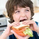 eating - a cute kid eating sandwich