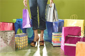 shop -  image of a woman standing among shopping bags.
