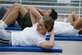 Excercise - Young people on mats, performing stomach excercises