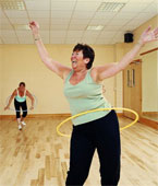 Fun - Two mature women excercising with plastic hoops, laughing