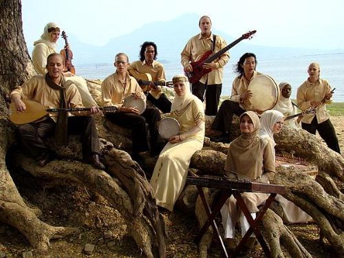 debu - Debu making a music video in Indonesia. Names of members and instruments from left to right: Mustafa lead vocal and composer playing the baglama, Shakurah backing vocal, playing the violin, Daood playing the drum, Dimas playing the guitar, Naseem playing the riq, Mujahid playing the bass, Wahab playing the tar, Naimah playing the mandolin, Saleem playing the flute, Najmah playing the santoor, Layla Wafiyyah playing the kanun.

Find Debu here:
 http://www.squidoo.com/naimah
and here: 
http://www.youtube.com/watch?v=EMK98gNBHNg