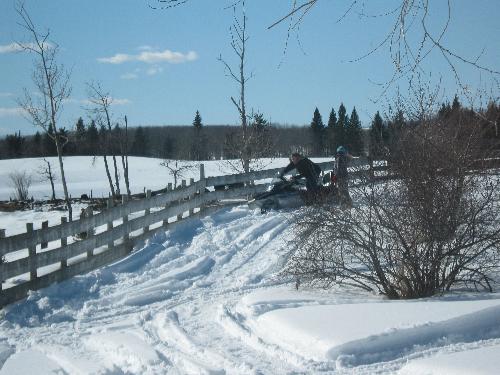 Stuck again - My dad out getting my sister and the snowmobile unstuck again.