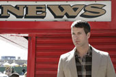 News - Caucasian man standing near a news sign