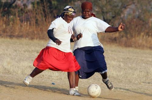 African Women Playing Soccer - I am a professional soccer player. I love to see the game being played in the mother land so this picutre is one of Women in Africa playing the game of soccer. You don't really see that in North America where the women are playing bare foot, and still have thier dresses on, and are at that age (they look like in thier 50's) playing soccer. GOTTA LOVE IT.