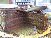 Cakes and more - Special tools are needed for more complex cake decorating, such as piping bags or syringes, and various piping tips. To use a piping bag or syringe, a piping tip is attached to the bag or syringe using a coupler. The bag or syringe is partially filled with icing which is sometimes colored. Using different piping tips and various techniques, a cake decorator can make many different designs. Basic decorating tips include open star, closed star, basketweave, round, drop flower, leaf, multi, petal, and specialty tips. Chocolate layer cake with chocolate frosting and shaved chocolate topping  Royal icing, marzipan (or a less sweet version, known as almond paste), fondant icing (also known as sugarpaste) and buttercream are used as covering icings and to create decorations. Floral sugarcraft or wired sugar flowers are an important part of cake decoration. Cakes for special occasions, such as wedding cakes, are traditionally rich fruit cakes or occasionally Madeira cakes (also known as whisked or fatless sponge), that are covered with marzipan and either iced using royal icing or sugarpaste. They are finished with piped borders (made with royal icing) and adorned with a piped message, wired sugar flowers, hand-formed fondant flowers, marzipan fruit, piped flowers, or crystallized fruits or flowers such as grapes or violets.